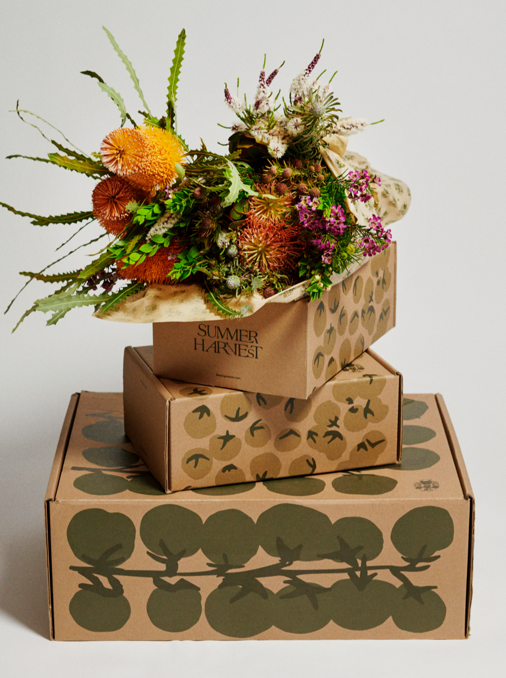 Stack Of Three Flamingo Estate Delivery Boxes With Flowers On Top