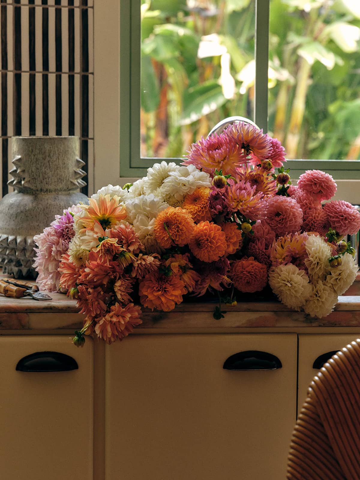 A vibrant bouquet of multi-colored flowers rests on a counter.