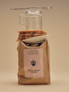 Bag Of Medium Roast Coffee With Coffee Accessories Balanced On Top