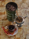Jar Of Coffee Beans Next To A Filled Coffee Cup, Saucer, Sugar And Spoon