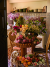 Dog In A Kitchen Next To A Table Full Of Flowers