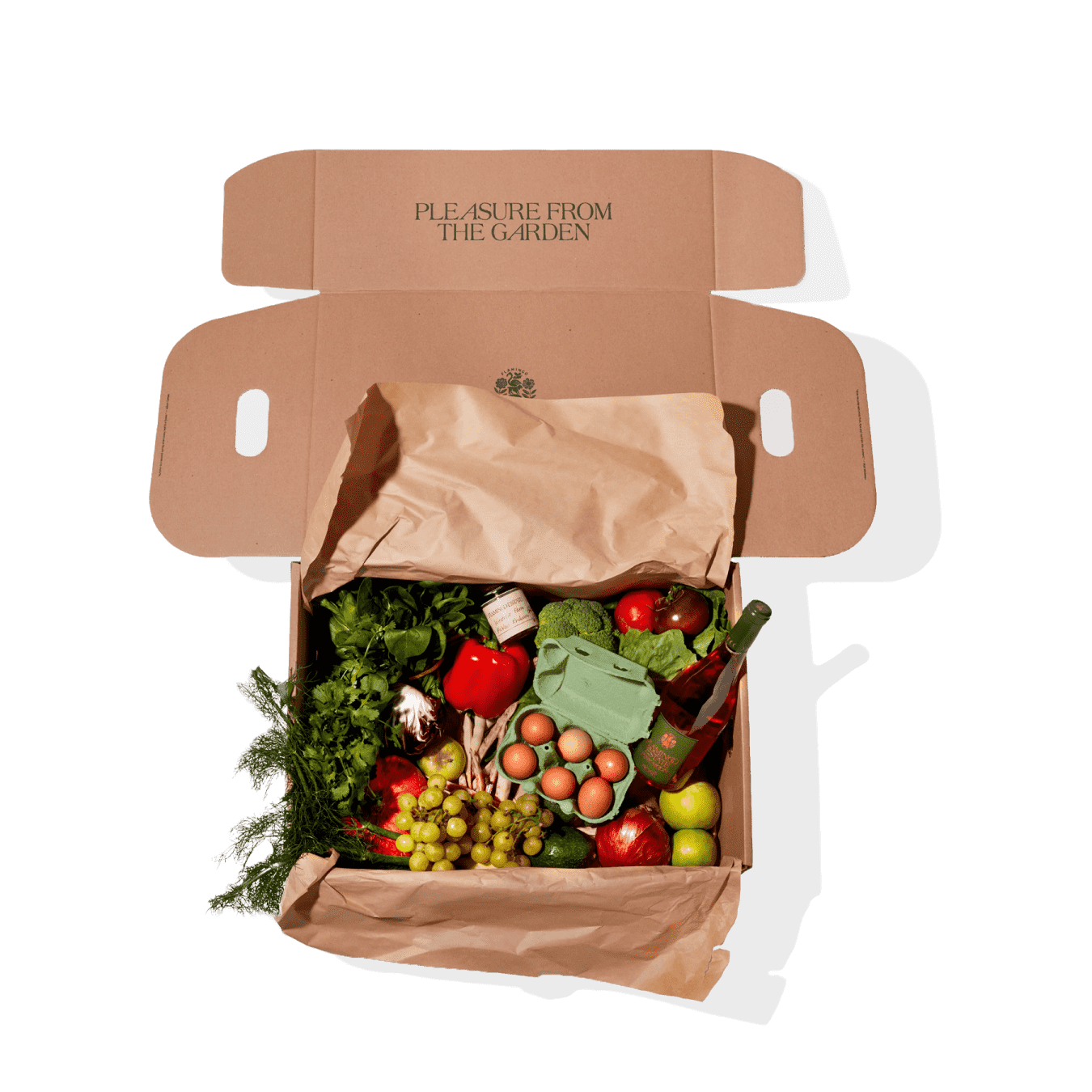 Box containing fresh produce and eggs placed on brown paper.
